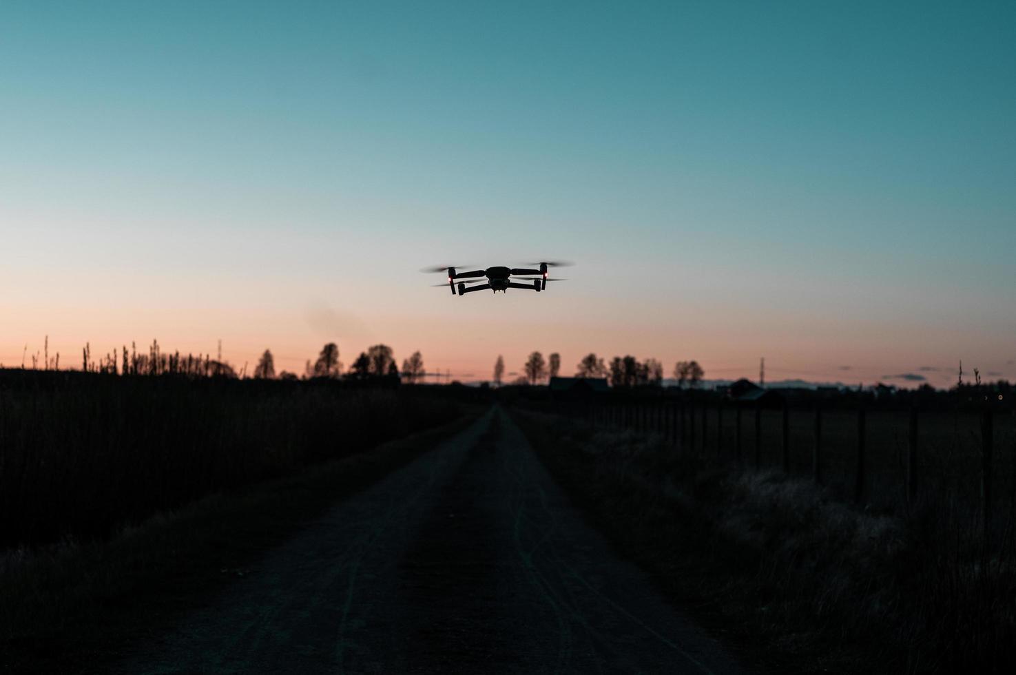 Drohne fliegt bei Sonnenuntergang über die Straße foto