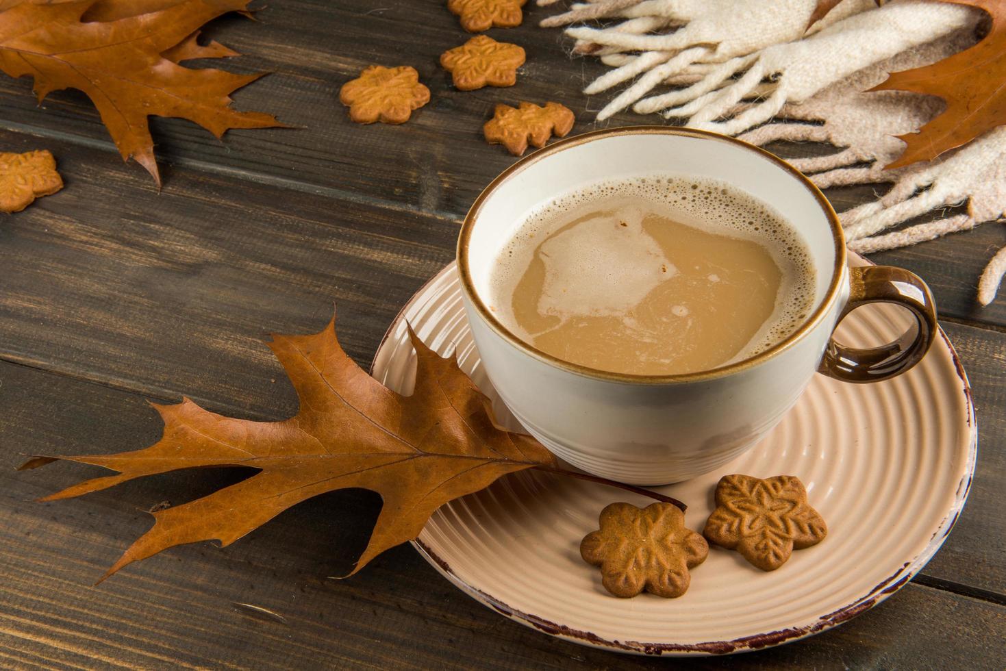 Kaffeetasse mit Herbstlaub und Keksen foto