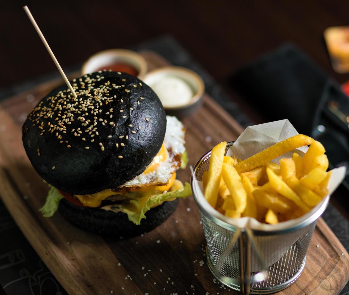 Schwarzbrotburger mit französischen Bratkartoffeln foto