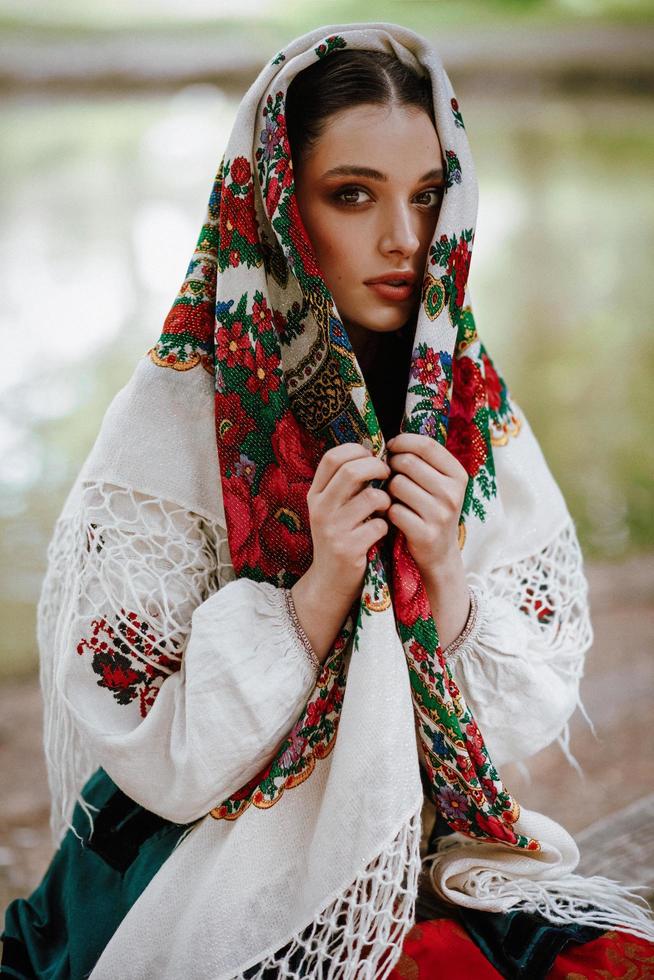 schönes Mädchen in einem traditionellen ethnischen Kleid mit einem gestickten Schal foto