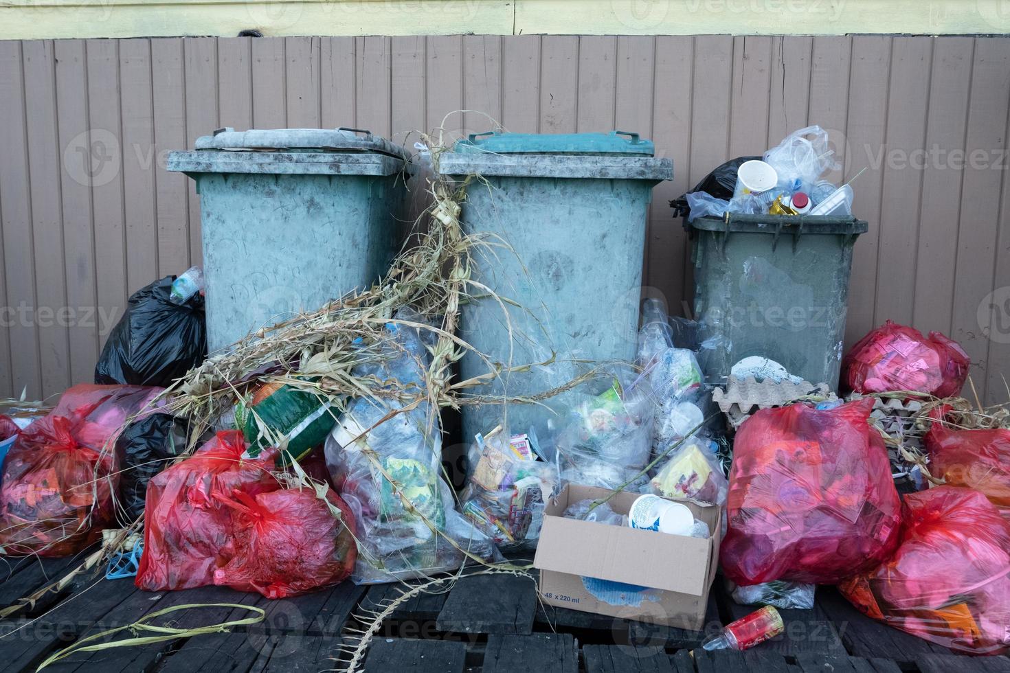 Haufen von Haushaltsabfällen, die das Fassungsvermögen der Mülleimer übersteigen, sodass sie schlecht riechen foto