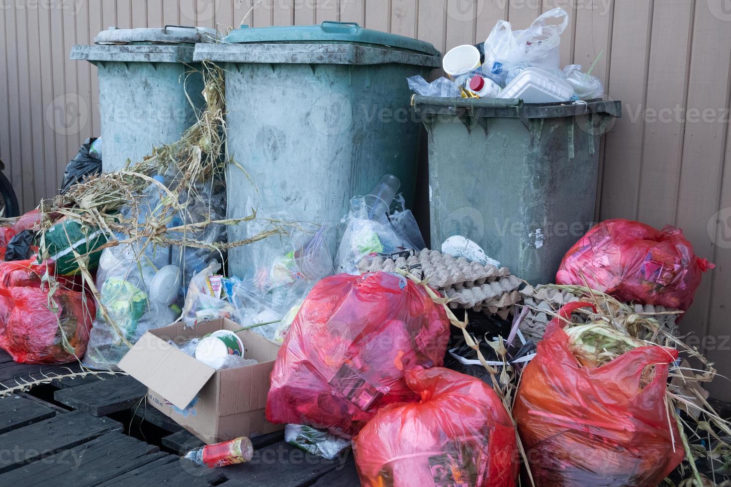Haufen von Haushaltsabfällen, die das Fassungsvermögen der Mülleimer übersteigen, sodass sie schlecht riechen foto
