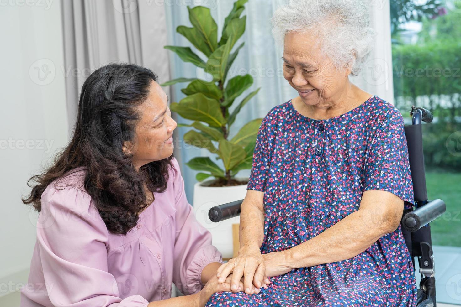 pflegekraft hilfe und pflege asiatische seniorin oder ältere patientin der alten dame, die zu hause im rollstuhl sitzt. foto