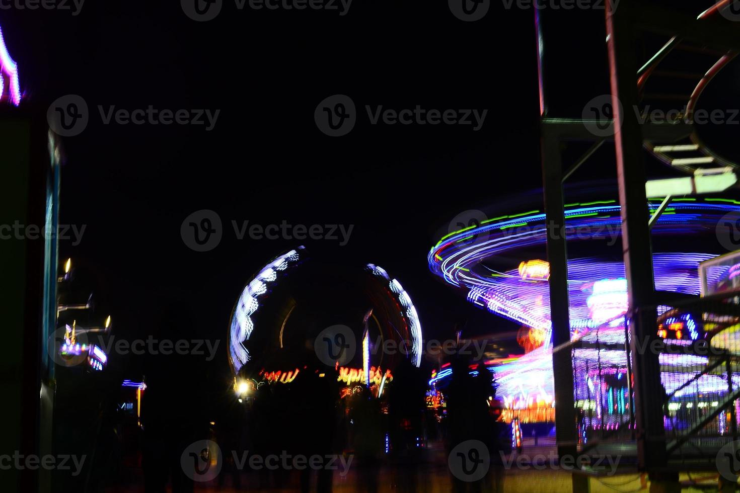 Park mit Fahrgeschäften in der Nacht foto