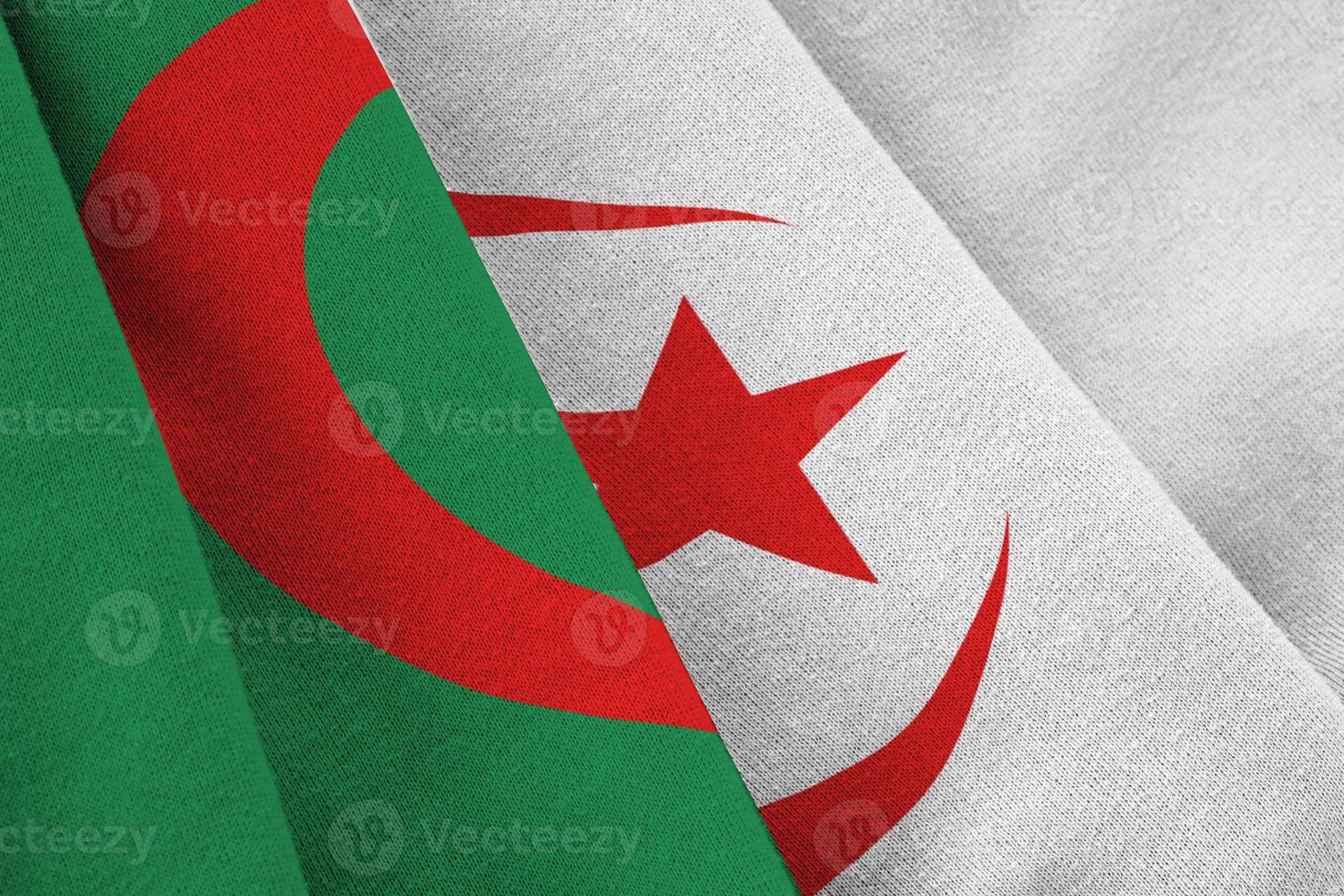 algerien-flagge mit großen falten, die nah oben unter dem studiolicht drinnen winken. die offiziellen symbole und farben im banner foto