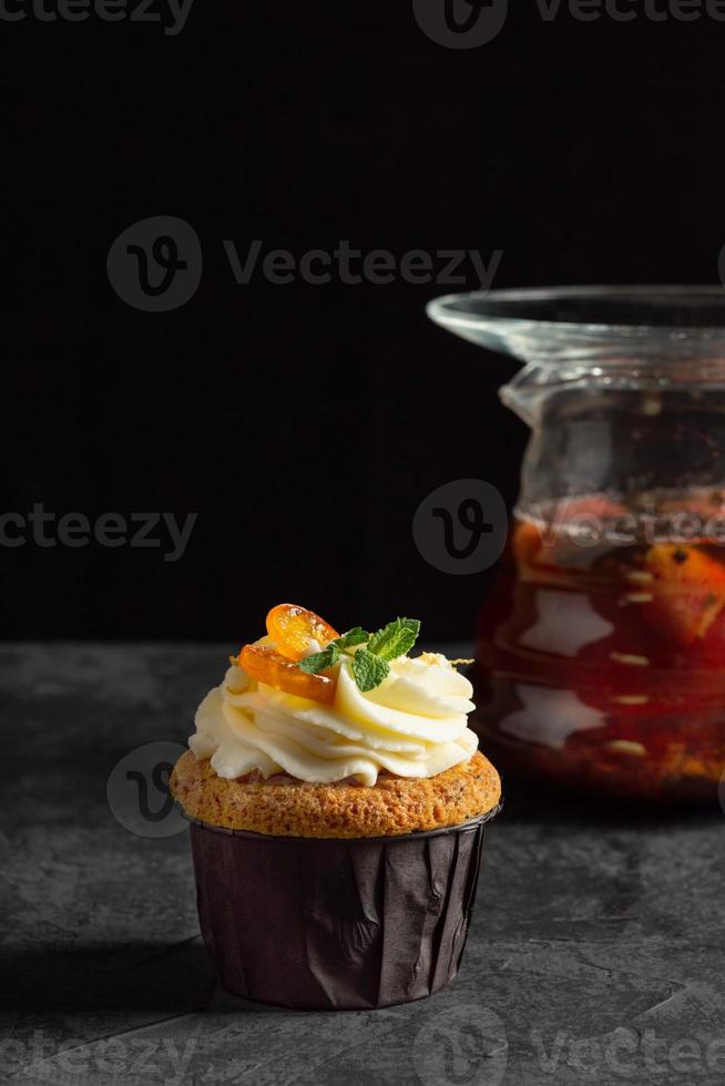 Cupcakes mit Käsecreme, dekoriert mit Beeren auf dunklem Hintergrund foto