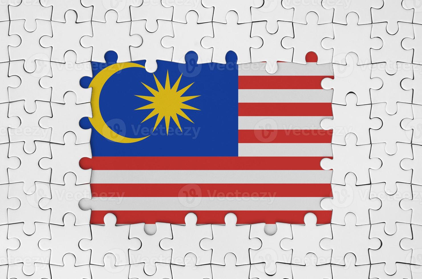 Malaysia-Flagge im Rahmen aus weißen Puzzleteilen mit fehlendem Mittelteil foto