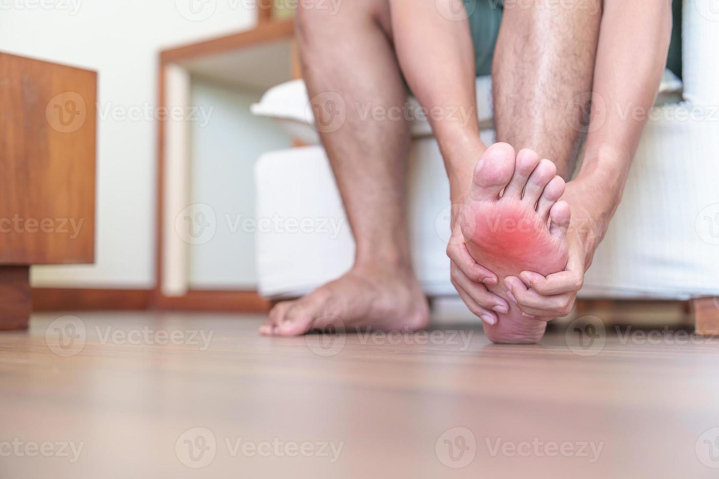 Mann mit Barfußschmerzen aufgrund von Plantarfasziitis und Ballenzehen oder Blasen aufgrund des Tragens enger Schuhe und langem Aufwachen oder Laufen. Gesundheit und medizinisches Konzept foto