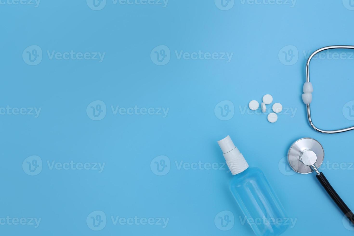 Pillen, die aus der Pille Flasche Spritze und Thermometer auf blauem Hintergrund verschüttet werden. Virenschutzkonzept. flache Lage, Draufsicht, Kopierbereich foto