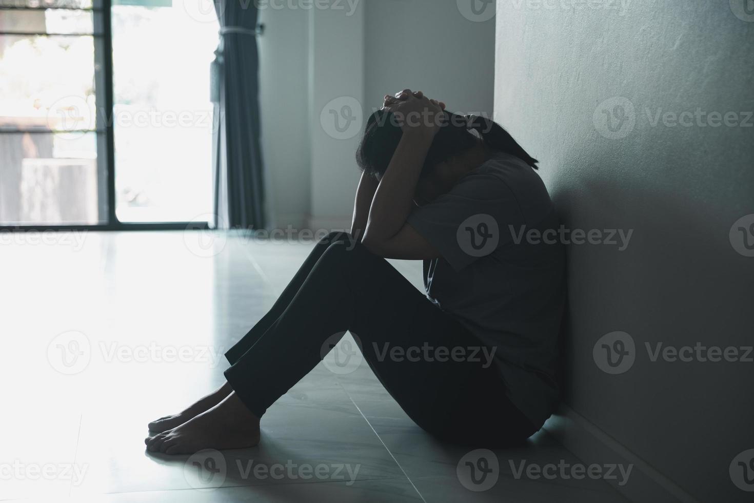 Schizophrenie mit einsamem und traurigem Depressionskonzept der psychischen Gesundheit. depressive frau, die zu hause an der wand sitzt, mit einem schatten an der wand, der sich elend fühlt. Frauen sind depressiv, ängstlich und unglücklich. foto