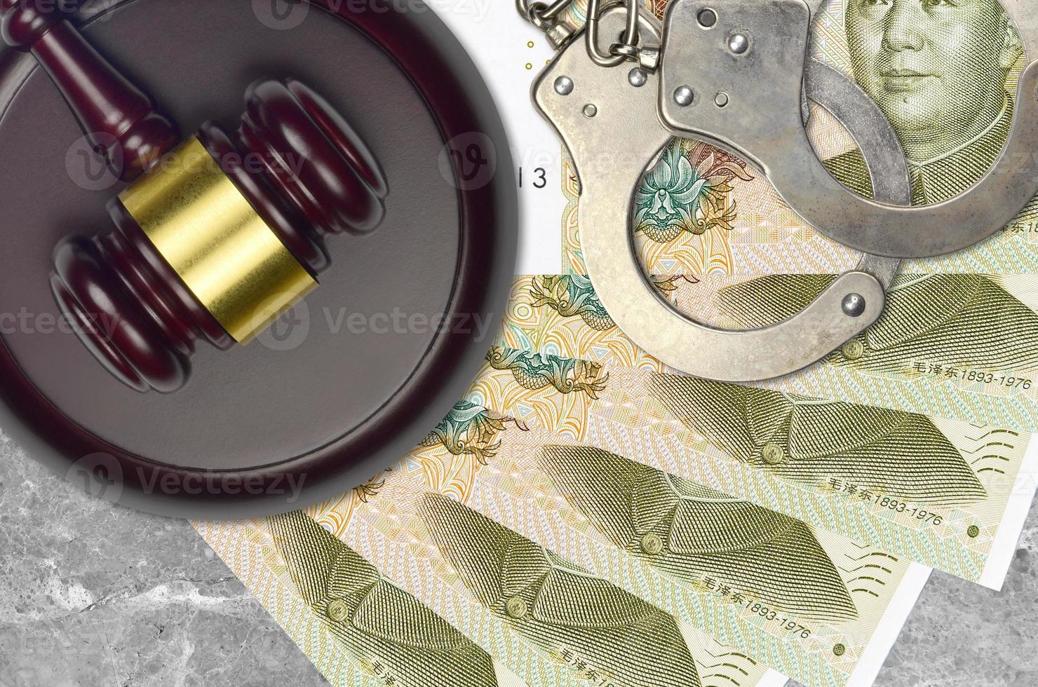 1 chinesische Yuan-Scheine und Richterhammer mit Polizeihandschellen auf dem Gerichtsschreibtisch. Konzept der Gerichtsverfahren oder Bestechung. Steuervermeidung foto