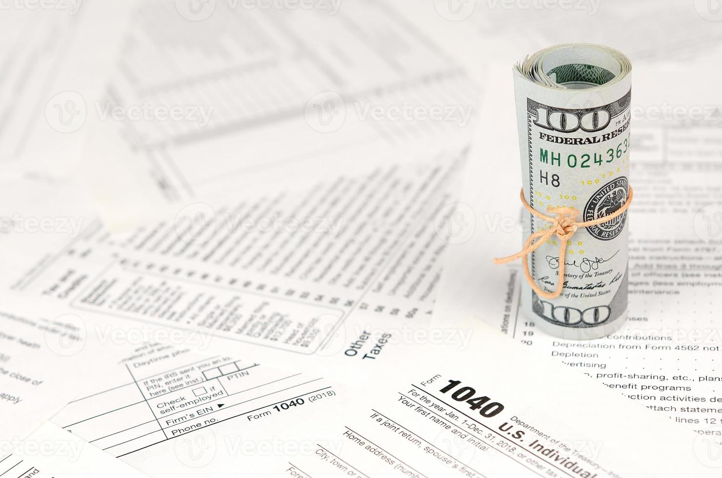 1040 individuelles Einkommensteuererklärungsformular mit einer Rolle amerikanischer Dollar-Banknoten foto