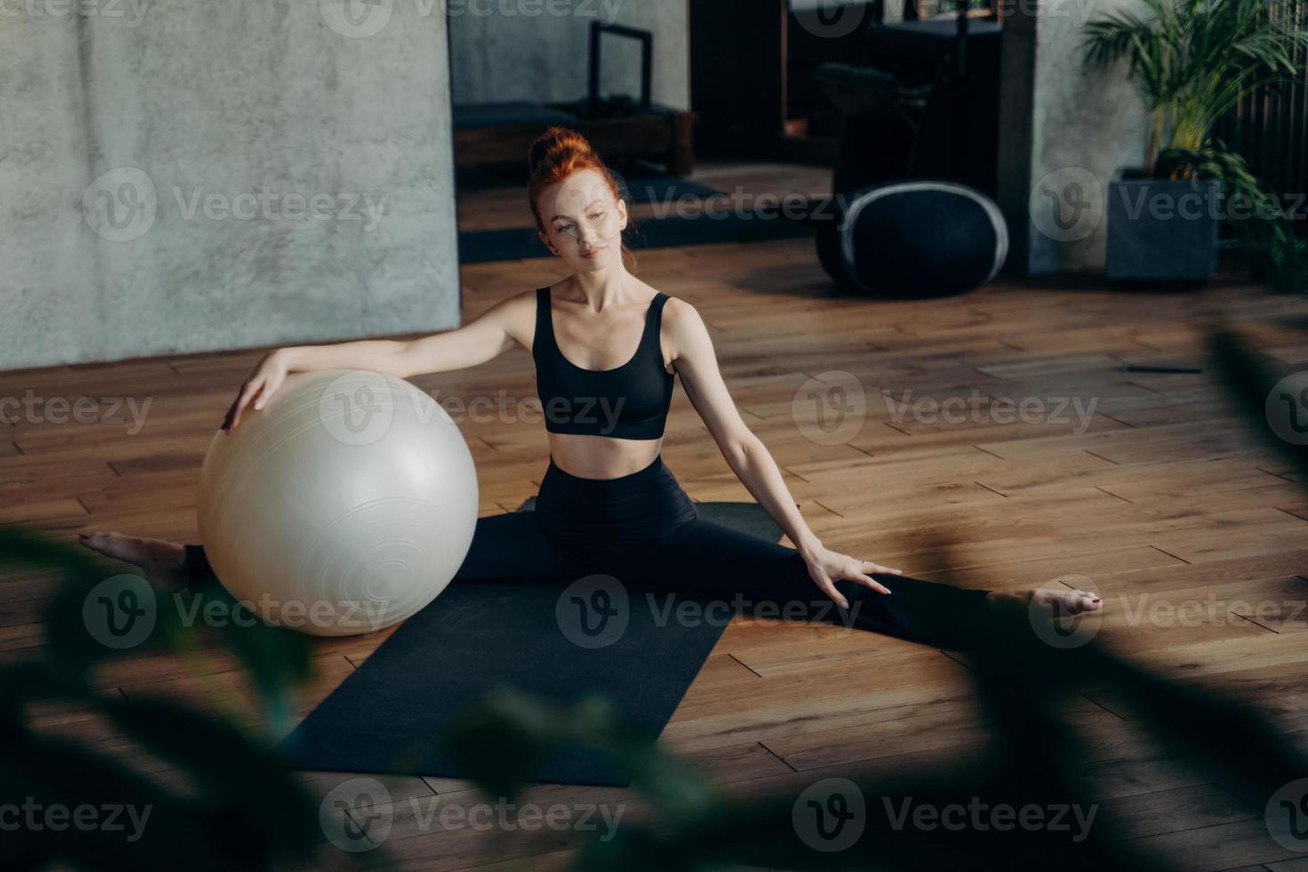 sportliche frau, die sich während des pilates-trainings mit übungsball entspannt foto