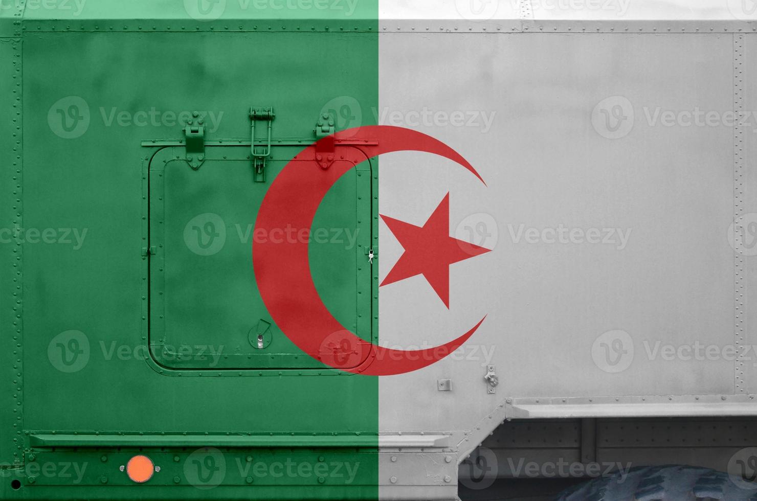 algerien-flagge auf seitenteil des militärischen gepanzerten lastwagens in der nähe. konzeptioneller hintergrund der armee foto