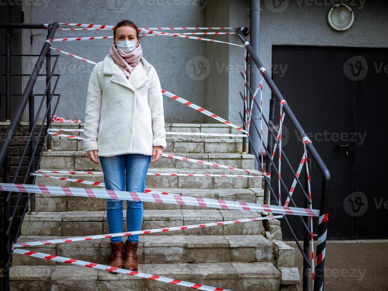 Foto eines Mädchens in einer Maske. mit Warnbändern auf der Straße stehen.