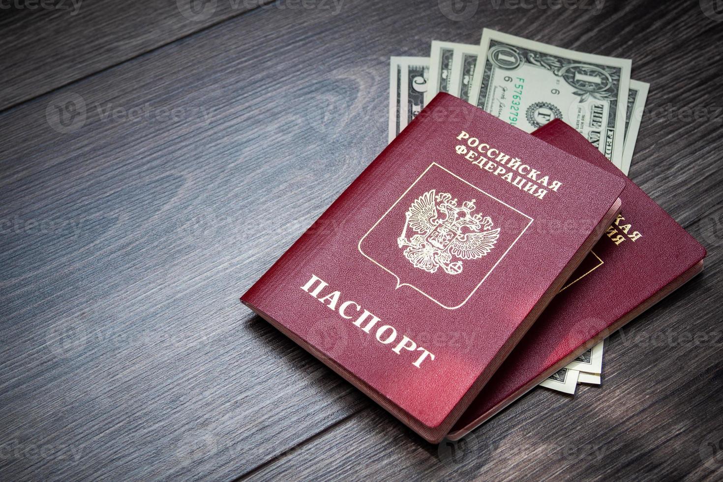 ein ausländischer Pass und Dollar auf einem hölzernen Hintergrund. foto