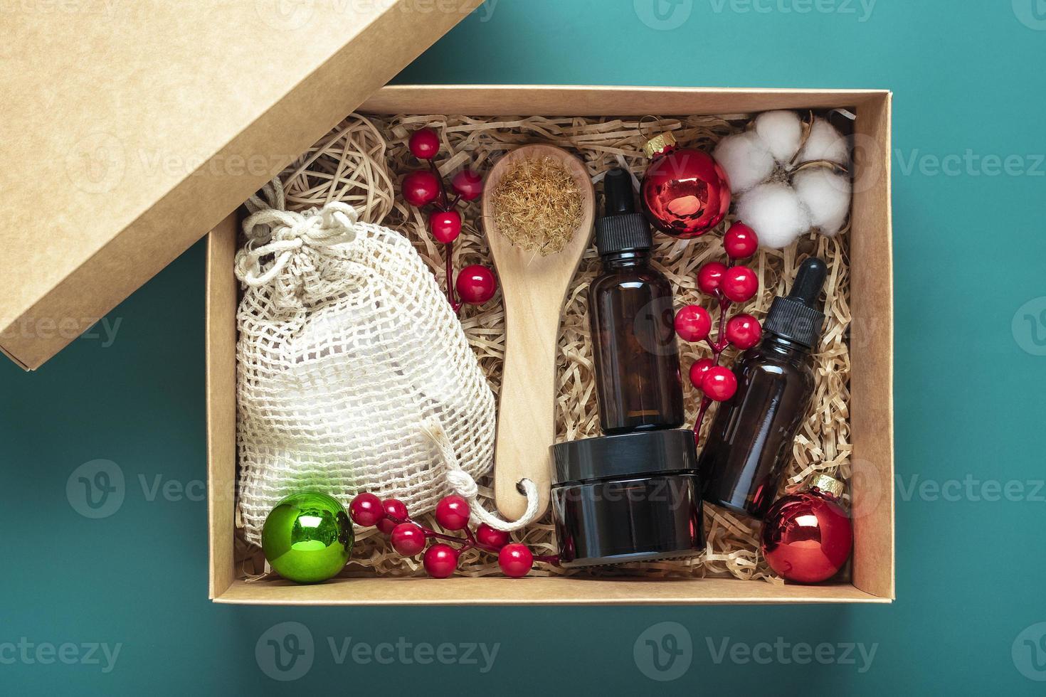 set für pflegebox umweltfreundliche kosmetiköl- und cremeflaschen, bürste zum waschen, wattepads auf grünem hintergrund geschenk für freundin, mutter zur feier des weihnachtskonzepts draufsicht flatlay foto