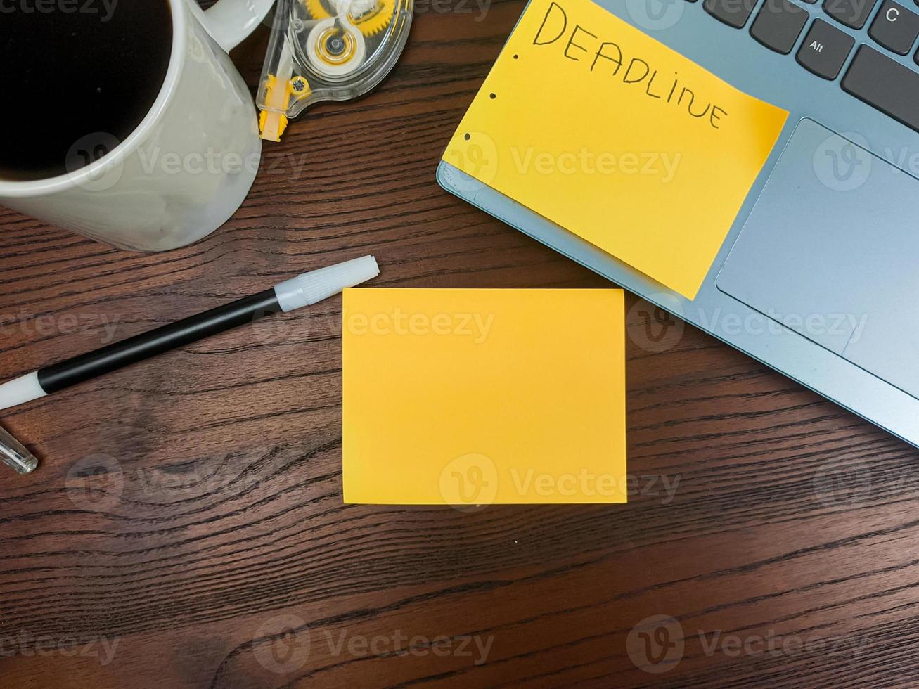 flach liegend, mock-up-gelbe noten. Arbeitsplatz im Hintergrund des Schreibtisches von oben. mit gelben notizen, laptops, bürobedarf, bleistiften und kaffeetassen im holztisch. foto