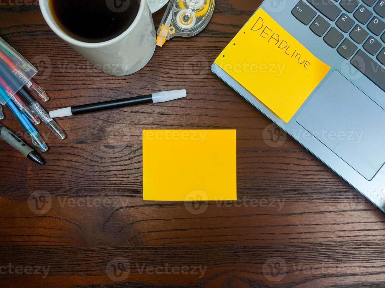 flach liegend, mock-up-gelbe noten. Arbeitsplatz im Hintergrund des Schreibtisches von oben. mit gelben notizen, laptops, bürobedarf, bleistiften und kaffeetassen im holztisch. foto