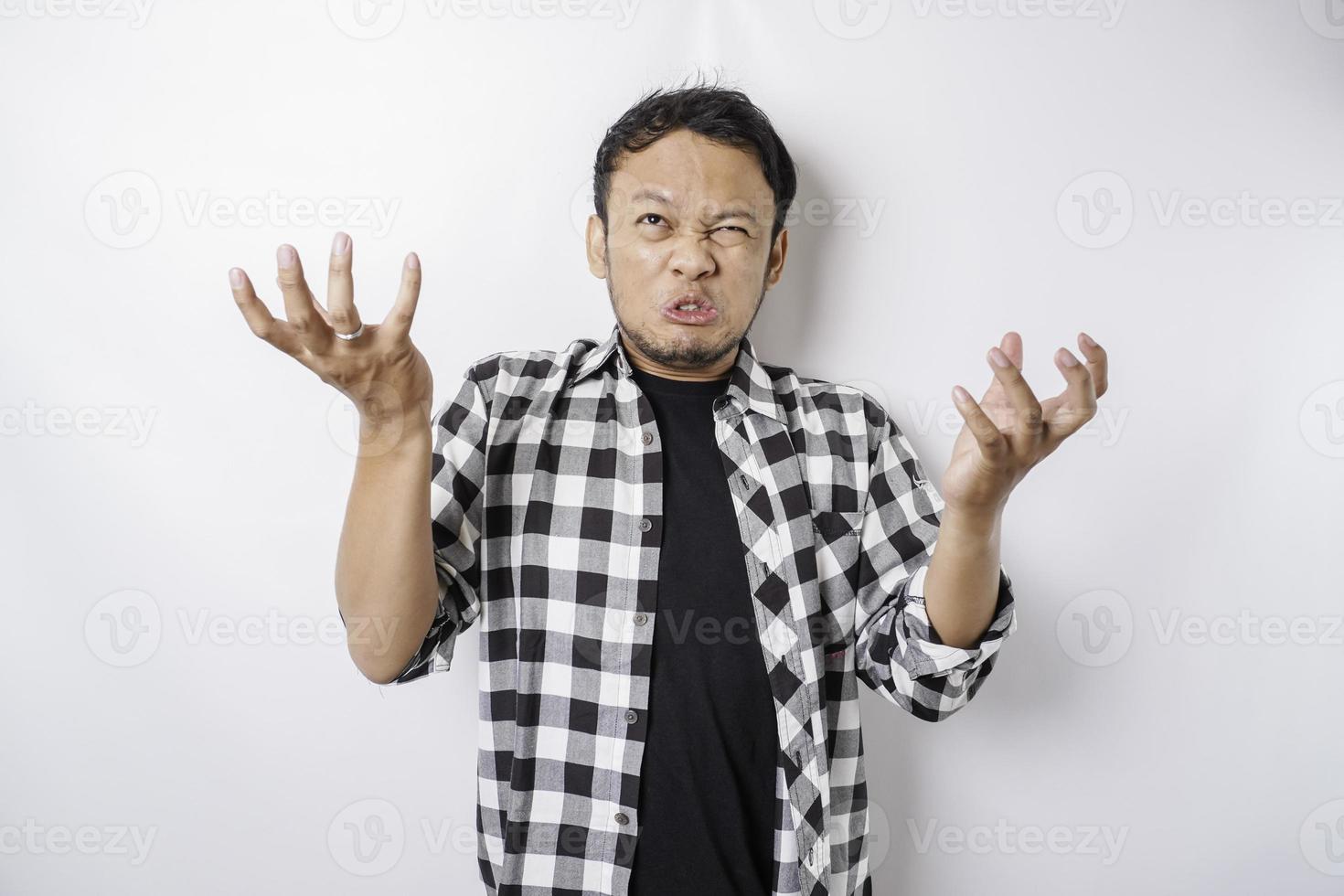 das wütende und wütende gesicht des asiatischen mannes im tartanhemd auf isoliertem weißem hintergrund. foto