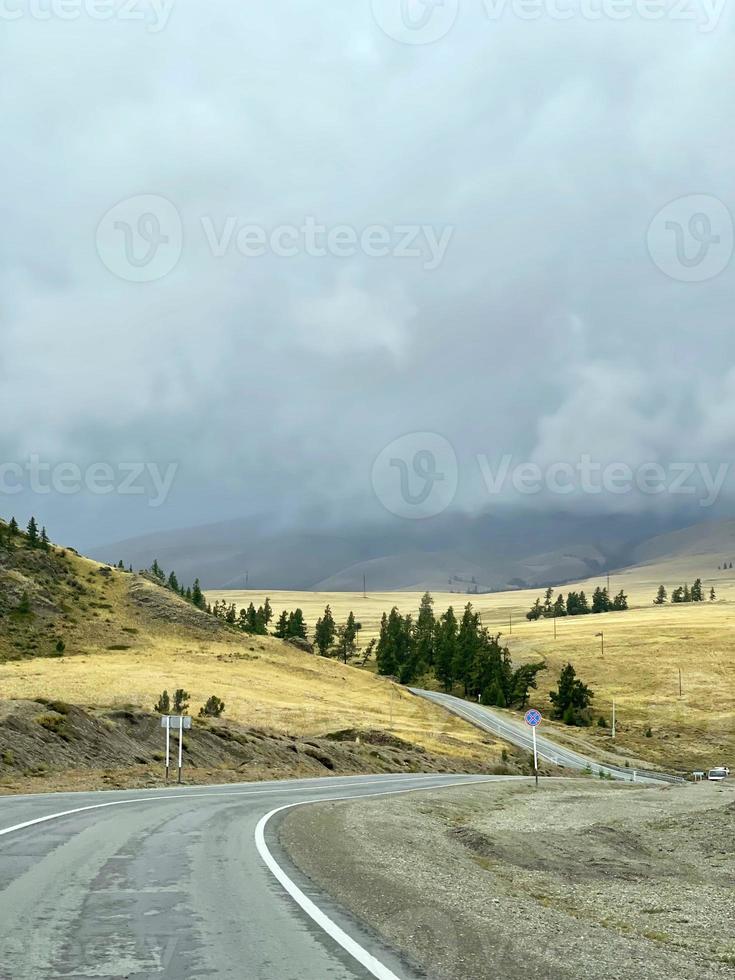 die kurvenreiche straße zwischen den hügeln in den bergen, ein teil des tschuisky-trakts, altai, russland foto