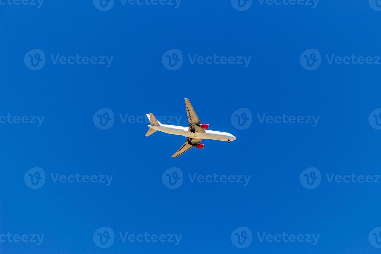 Ein Flugzeug, das am blauen Himmel ohne weiße Wolken fliegt foto