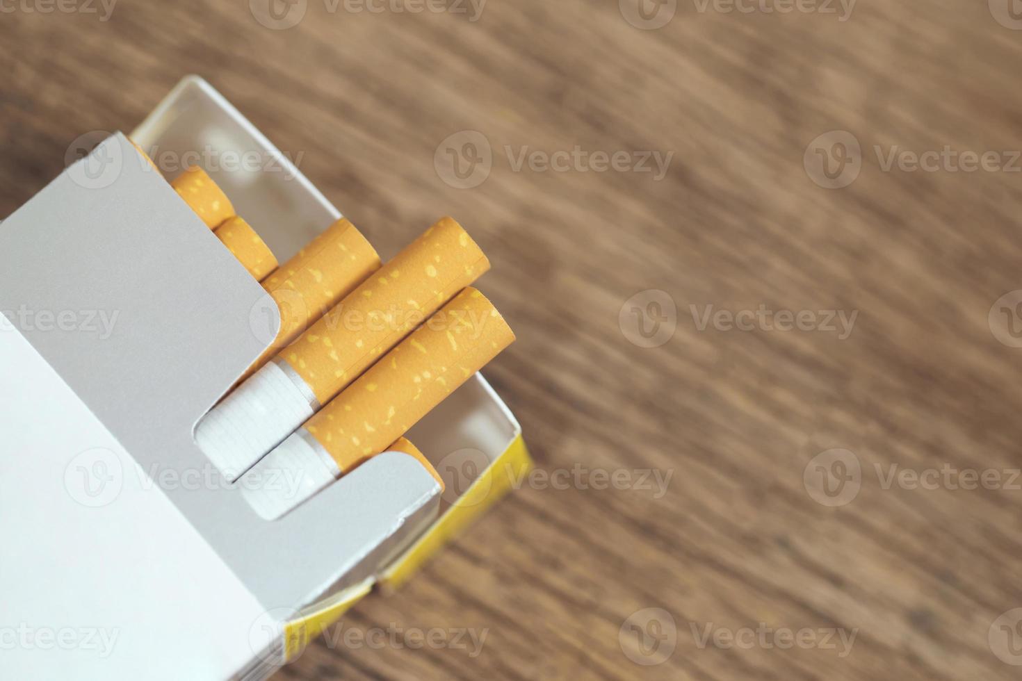 Ziehen Sie es von der Zigarettenpackung ab Rauchen vorbereiten. Verpackungslinie auf den Holztisch gelegt. Foto filtert natürliches Licht.