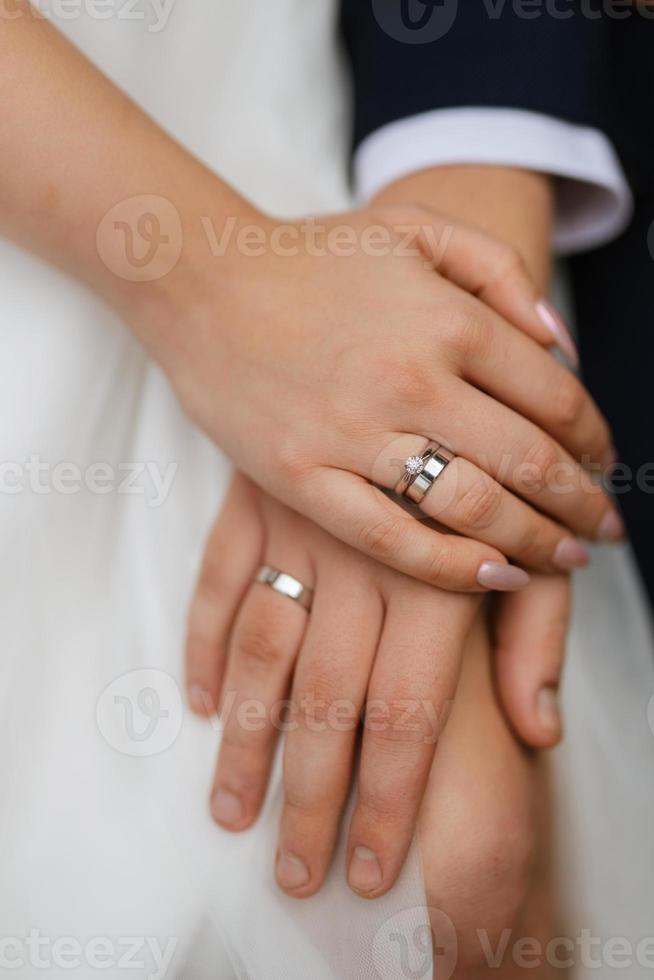 das Brautpaar hält zärtlich die Hände zwischen ihnen Liebe und Beziehungen foto