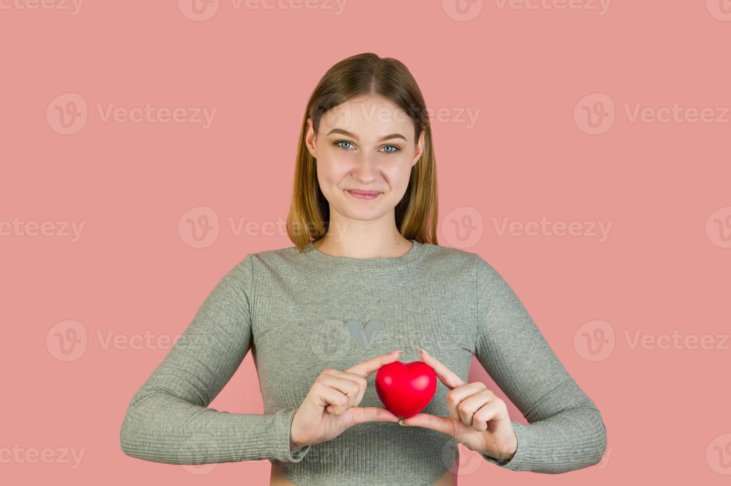 nahaufnahme studioportrait der jungen frau, die heart.st valentinstagkonzept hält foto