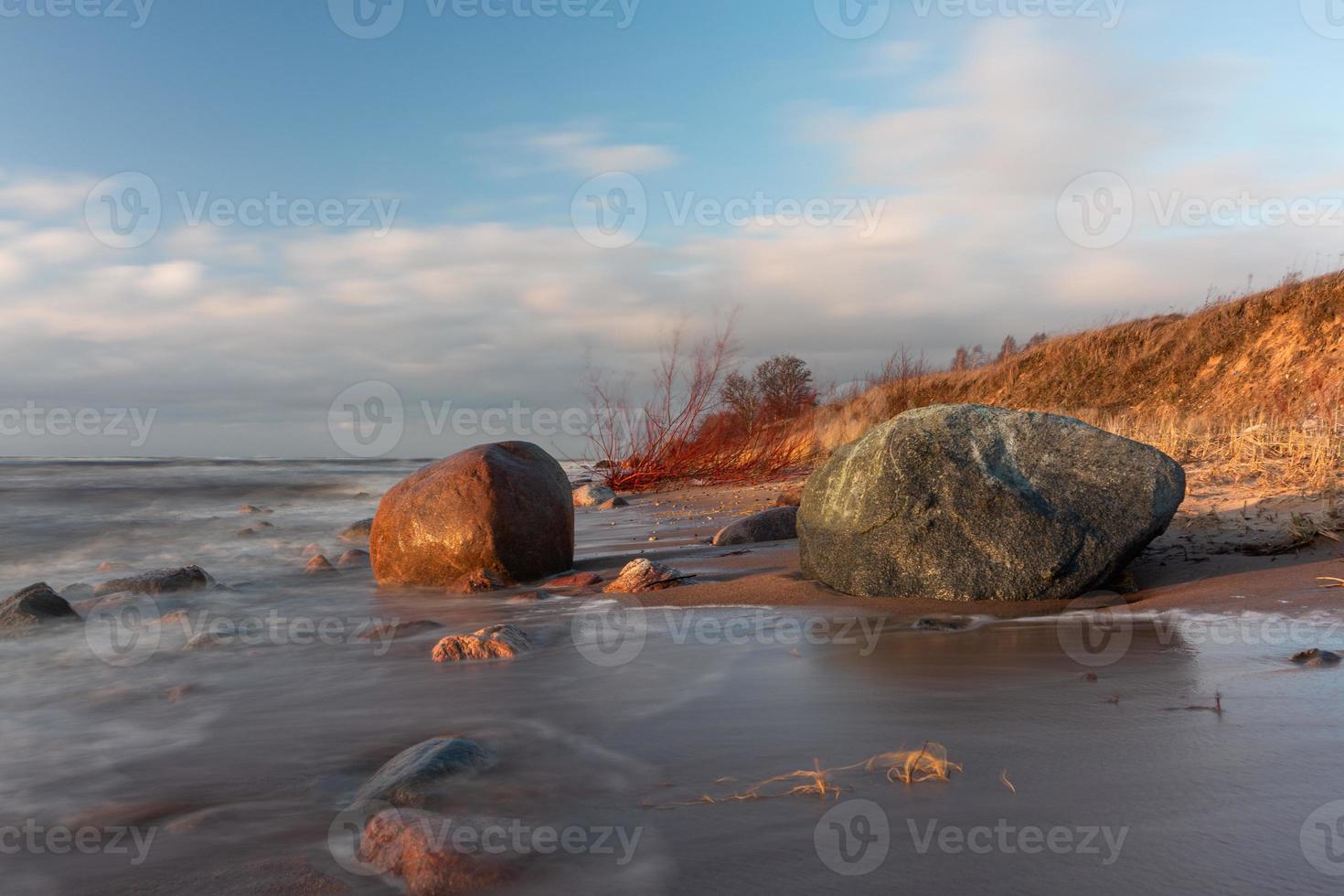 Ostseeküste mit Kieselsteinen und Eis bei Sonnenuntergang foto
