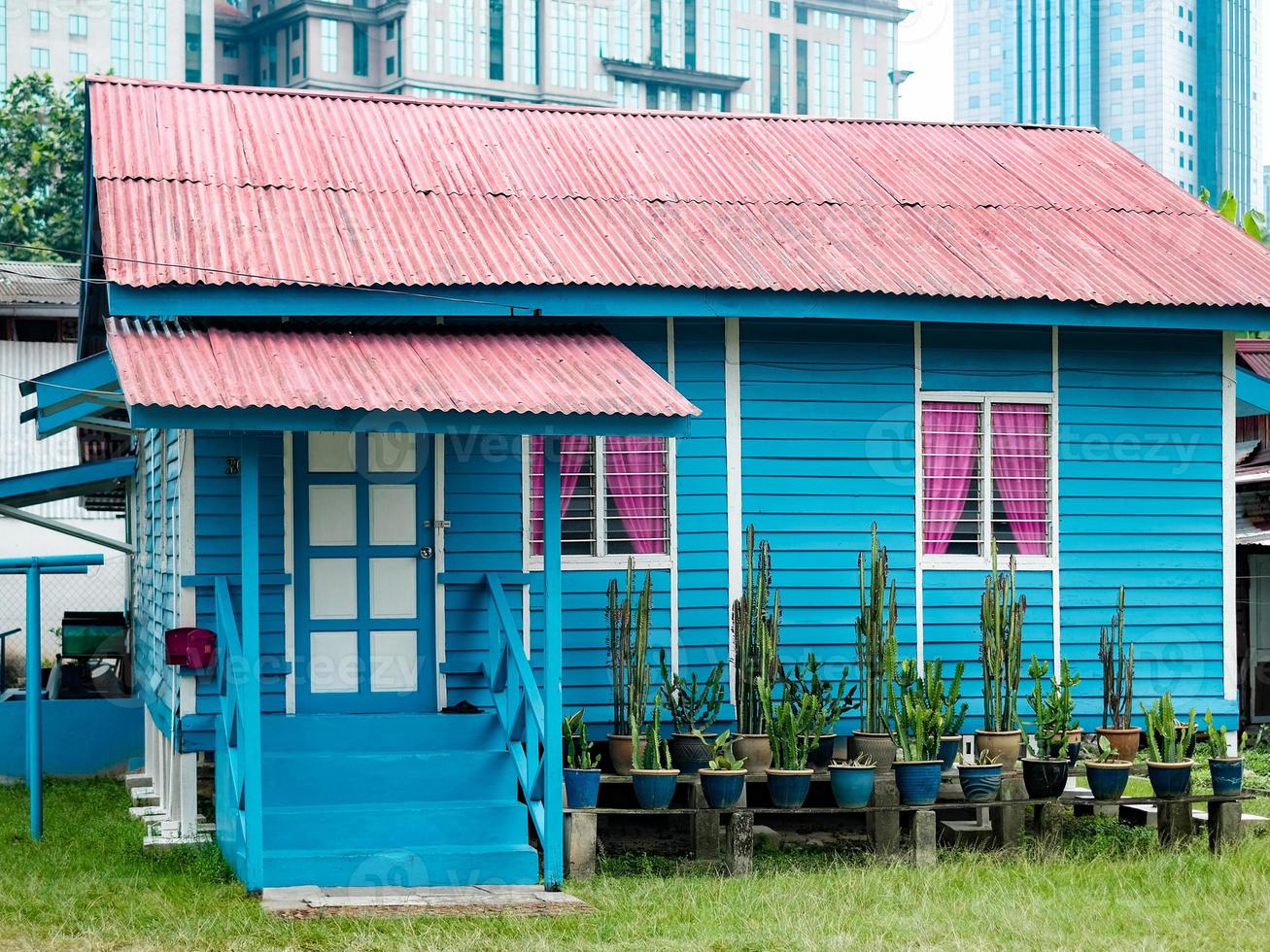 ein blaues haus mit rosa vorhang foto