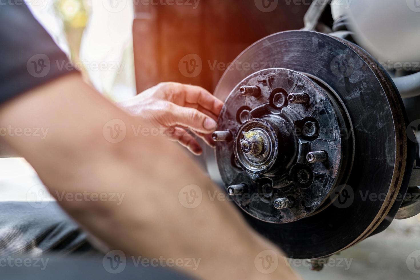 Nahaufnahme Scheibe des Bremsentechnikers Antriebswelle und Fett im Lagergehäuse des Rades prüfen Service Überprüfung der Wartungszeit des Autos auf Fahrsicherheit foto