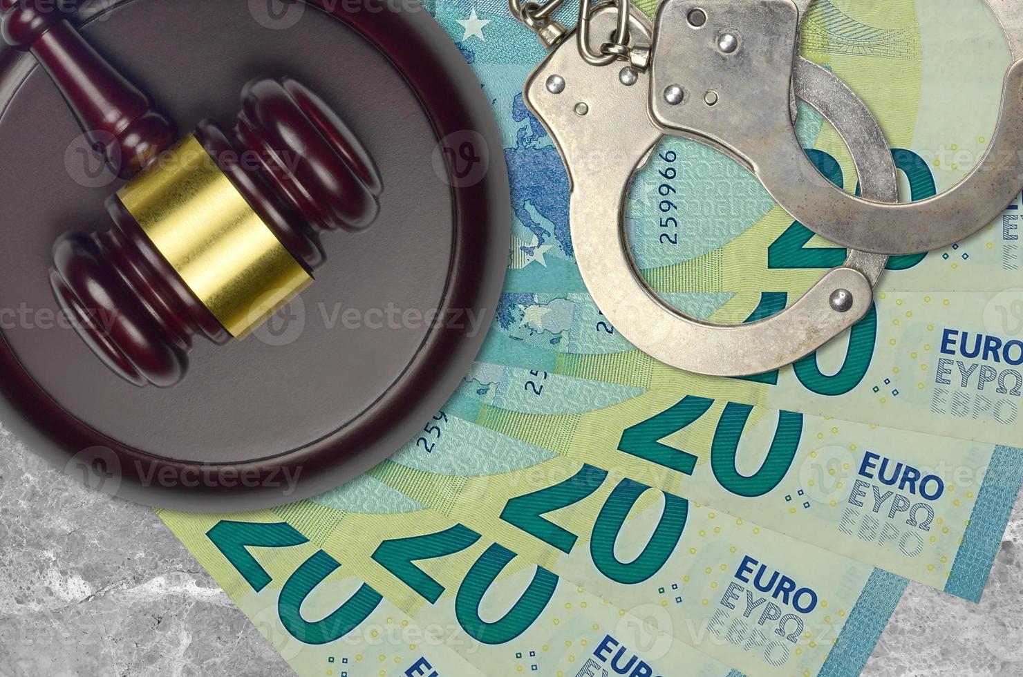 20-Euro-Scheine und Richterhammer mit Polizeihandschellen auf Gerichtsschreibtisch. Konzept der Gerichtsverfahren oder Bestechung. Steuervermeidung foto