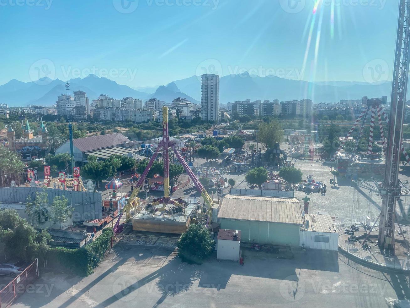 Panoramablick auf die Stadt durch das Glas aus der Kabine des Riesenrads. Reitende Touristen in einer geschlossenen, runden Metallkabine. Tour Karussell foto