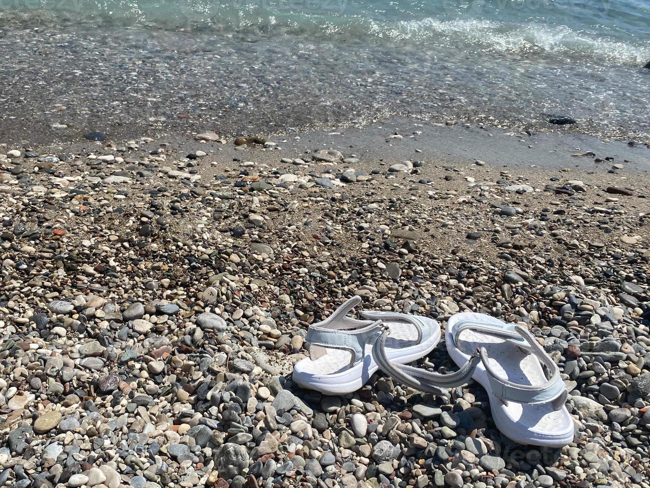 Flip Flops am Kiesstrand. Sommerurlaub am Meer. Ansicht von oben. Platz kopieren foto