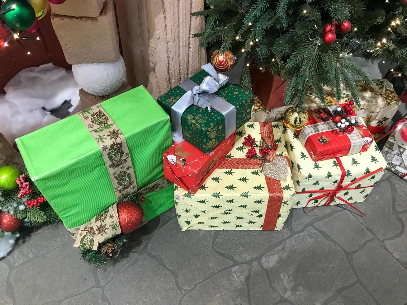 bunte schachteln mit weihnachtsgeschenken unter dem weihnachtsbaum. Weihnachtsinterieur. Dekorationen des neuen Jahres. Neujahr. Weihnachten foto