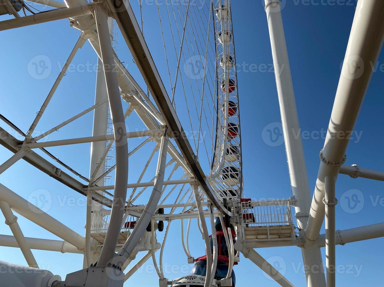 großes weißes Riesenrad gegen den blauen Himmel. Teil der Attraktion auf blauem Hintergrund mit Kopierraum. Kabinen, Besichtigung foto