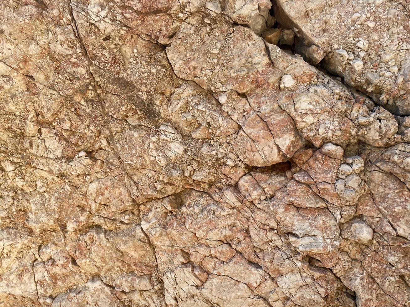 hintergrund und textur von bergschichten und rissen im sedimentgestein an der felswand. Stein Textur Nahaufnahme Hintergrund foto