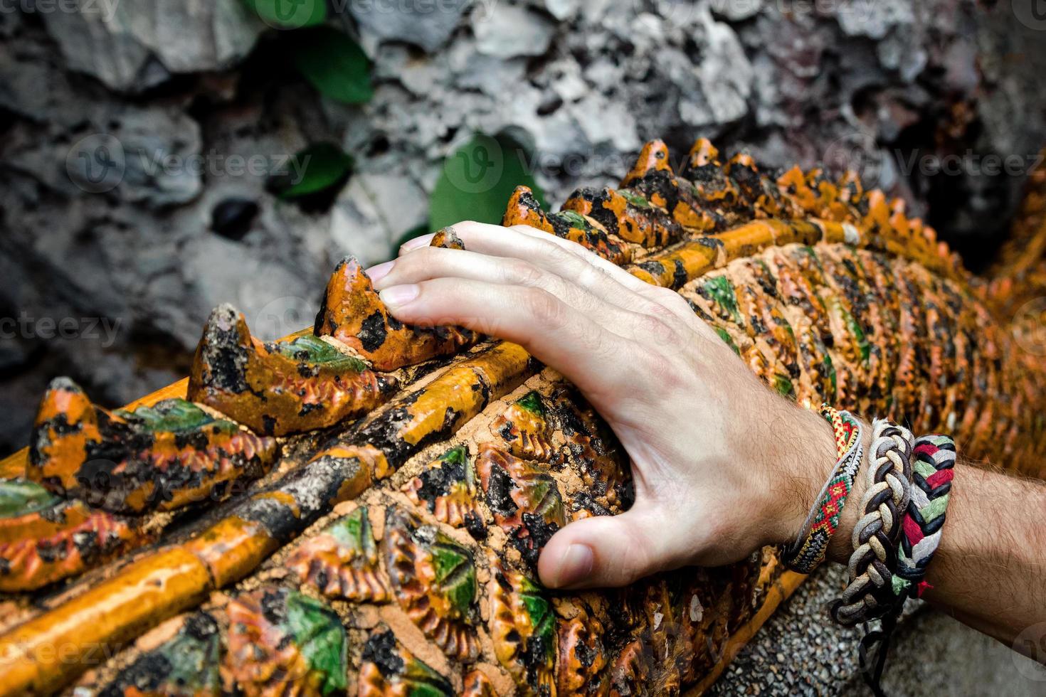 Mannhand auf den bemalten Geländern im buddhistischen Tempel. foto