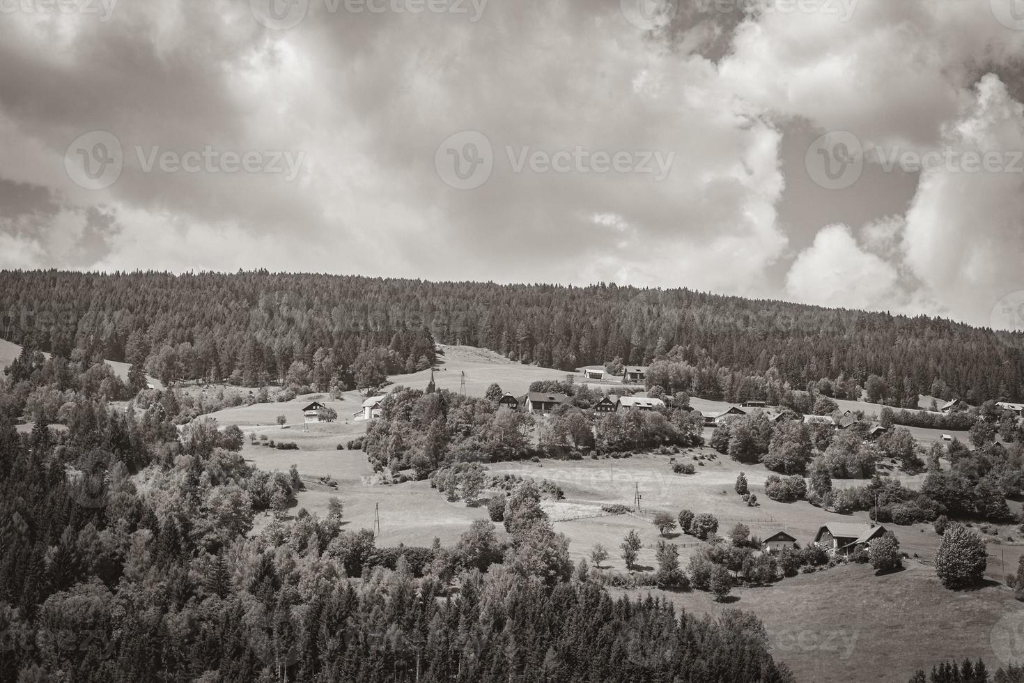 wunderschönes bewaldetes alpenpanorama mit dorf und hütten österreich. foto