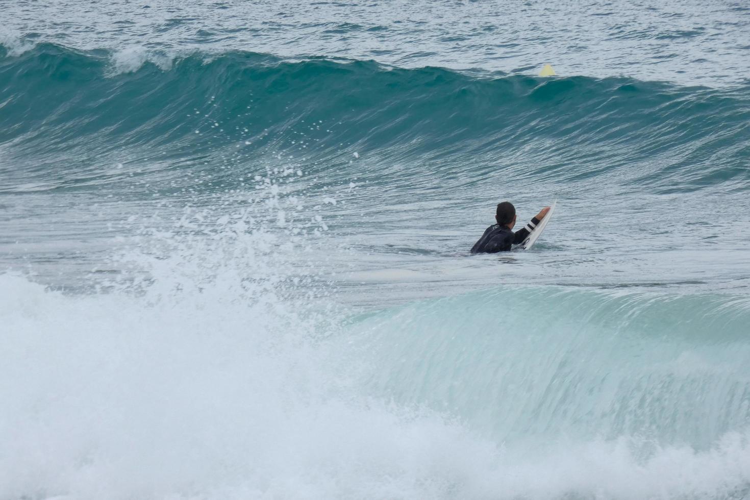 Surfer, die Wellen in einem sturmgepeitschten Meer reiten foto