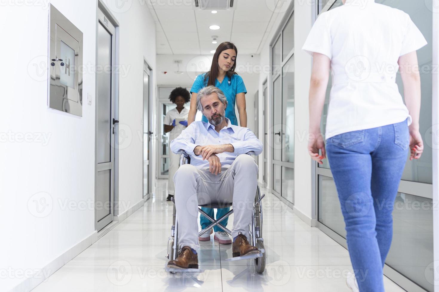 rollstuhlpatient mit professioneller ärztin und krankenschwester fachpersonal im korridor des krankenhauserholungszentrums foto