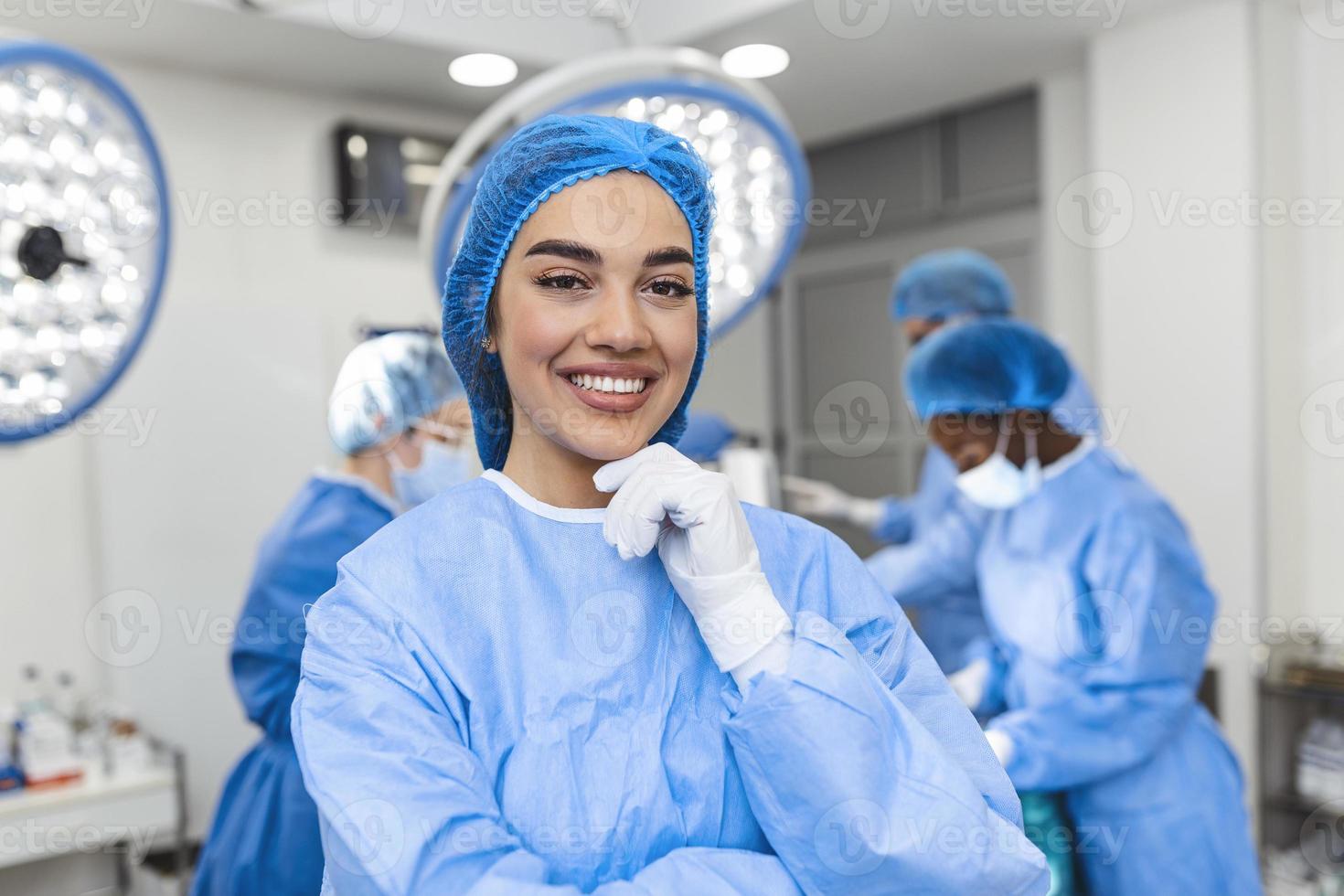 Porträt einer weiblichen Krankenschwester, Chirurgin oder Mitarbeiterin, gekleidet in OP-Kittel, Maske und Haarnetz im Operationssaal des Krankenhauses, die Augenkontakt macht, lächelnd, zufrieden, glücklich, in die Kamera schaut foto