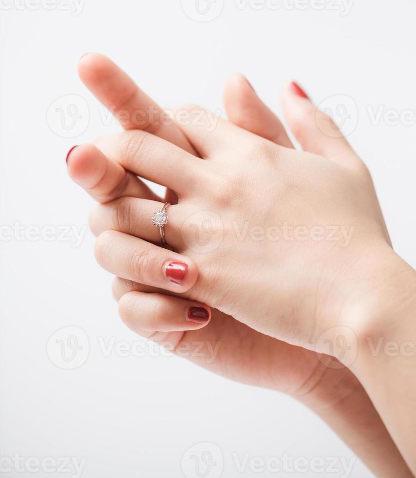 Nahaufnahme eines eleganten Verlobungsdiamantrings am Finger der Frau foto