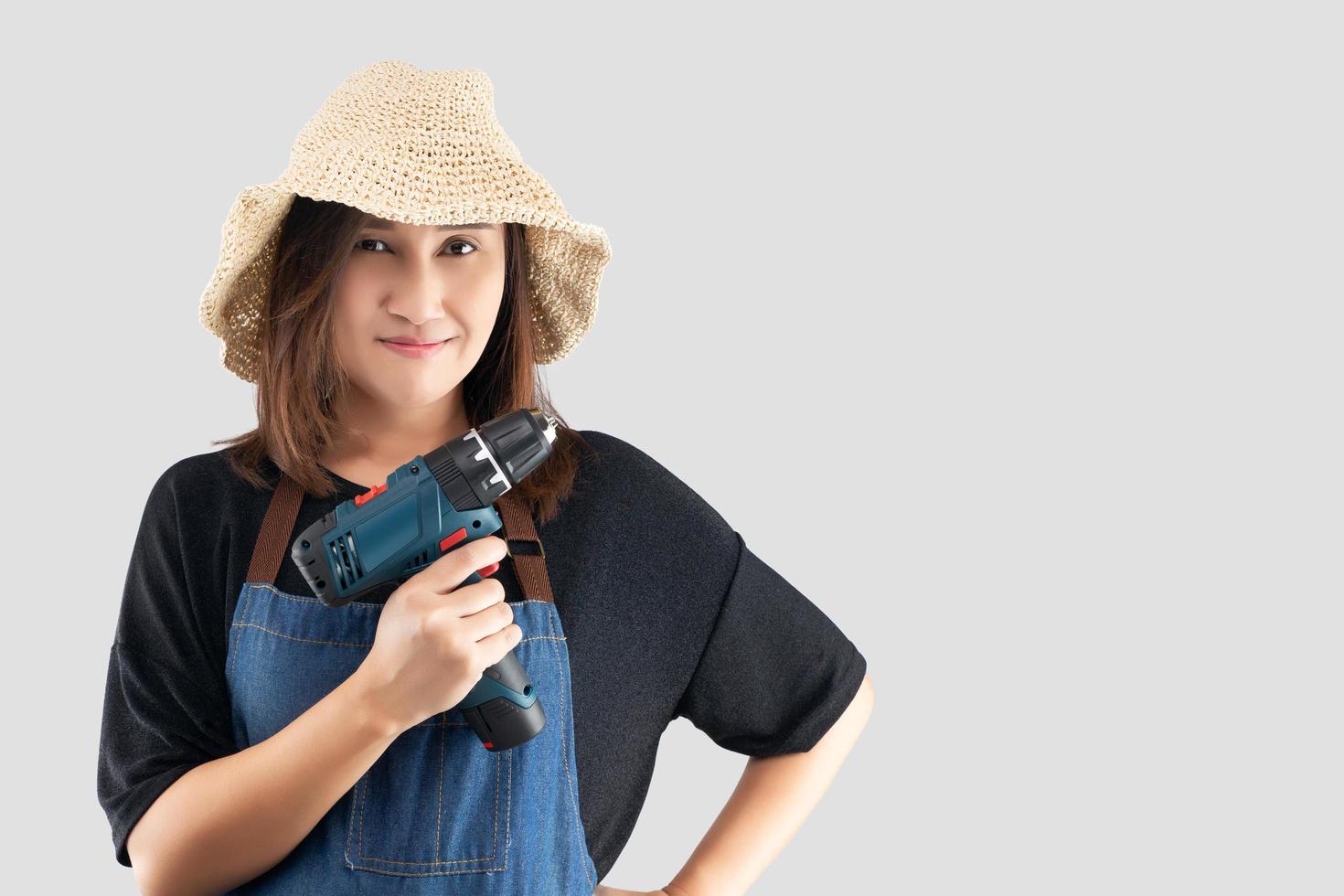 handwerkerin, die eine schnurlose elektrische bohrmaschine hält foto