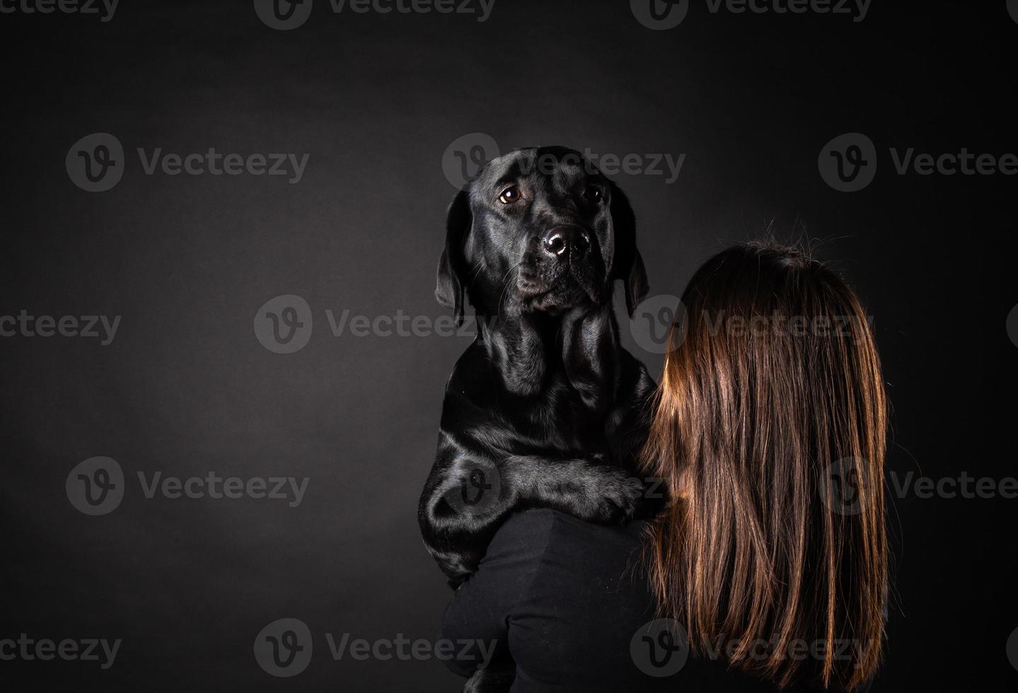 Ein Mädchen hält einen Labrador-Retriever-Hund in den Armen. foto