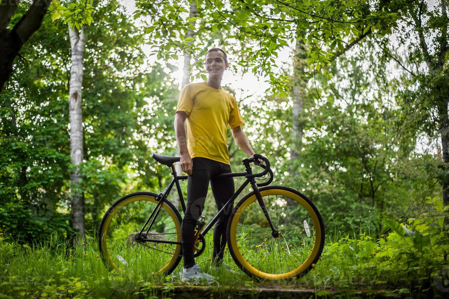 Ein junger Mann hielt mit seinem Fahrrad in einem öffentlichen Park an, um sich auszuruhen. foto