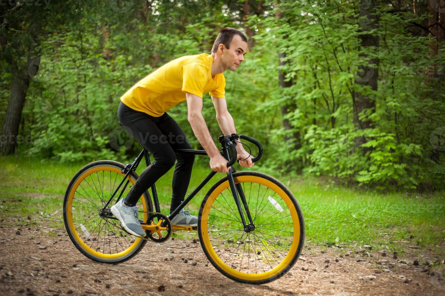 Porträt eines jungen Mannes, der sich auf einem Fahrrad fortbewegt. foto