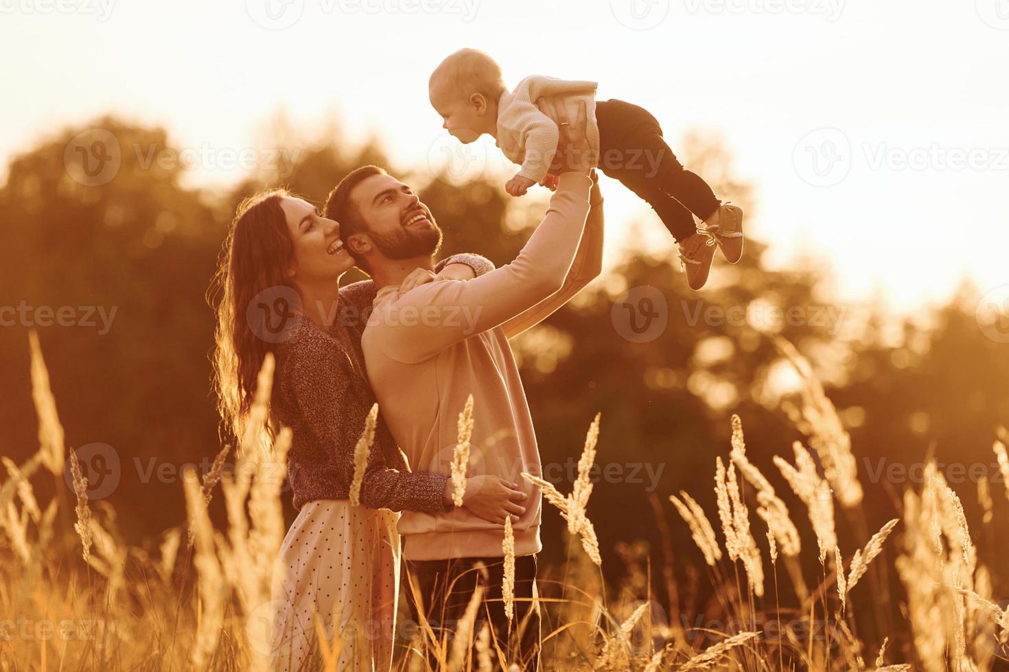 von Sonnenlicht beleuchtet. glückliche familie von mutter, familie und kleinem baby ruht im freien. schöne sonnige herbstnatur foto
