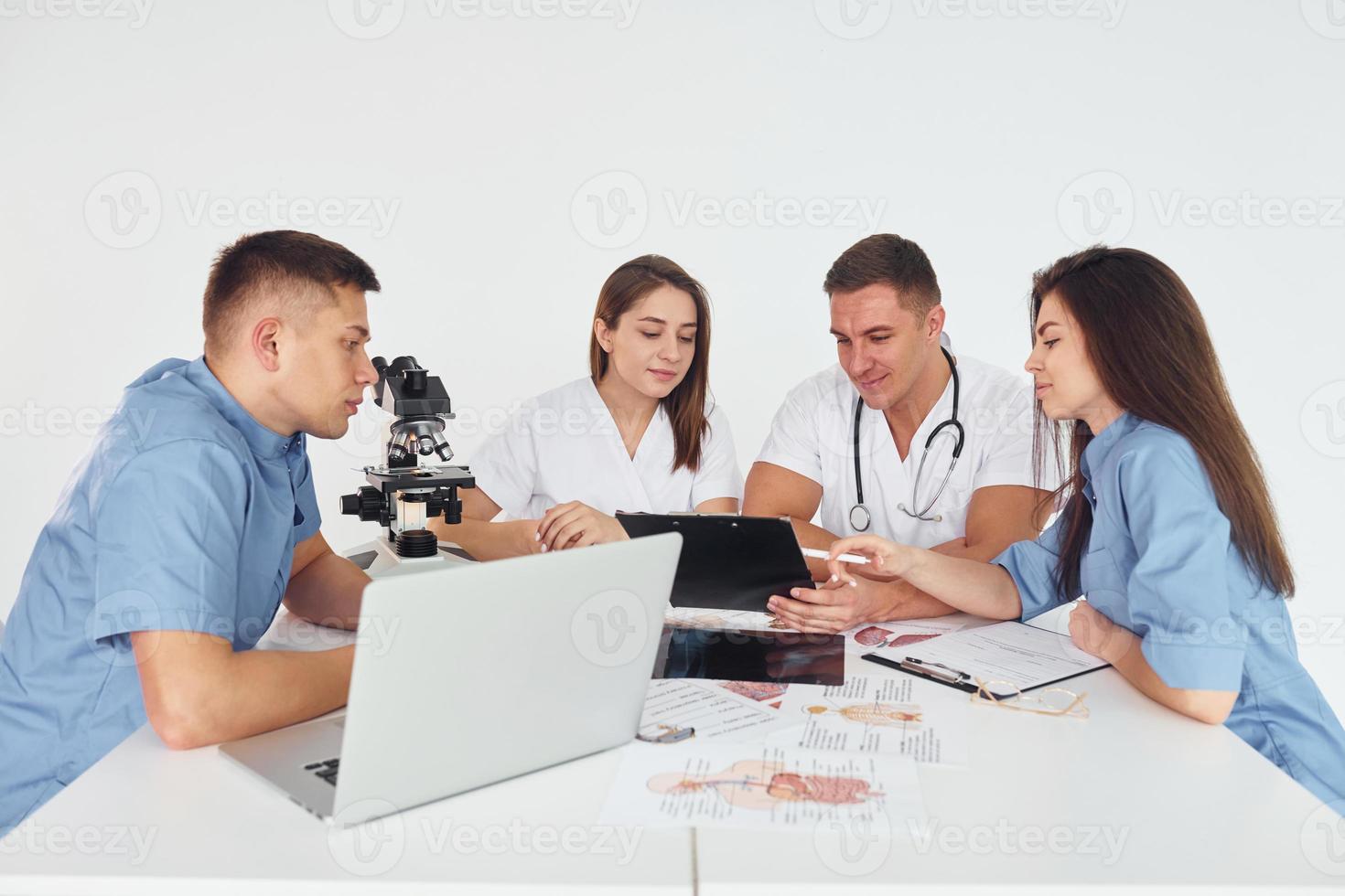 Gruppe junger Ärzte arbeitet in der modernen Praxis zusammen foto
